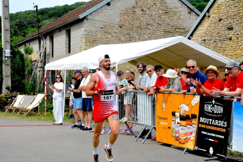 Arrivée d'un coureur dans le village, devant le public massé derrière les barrières