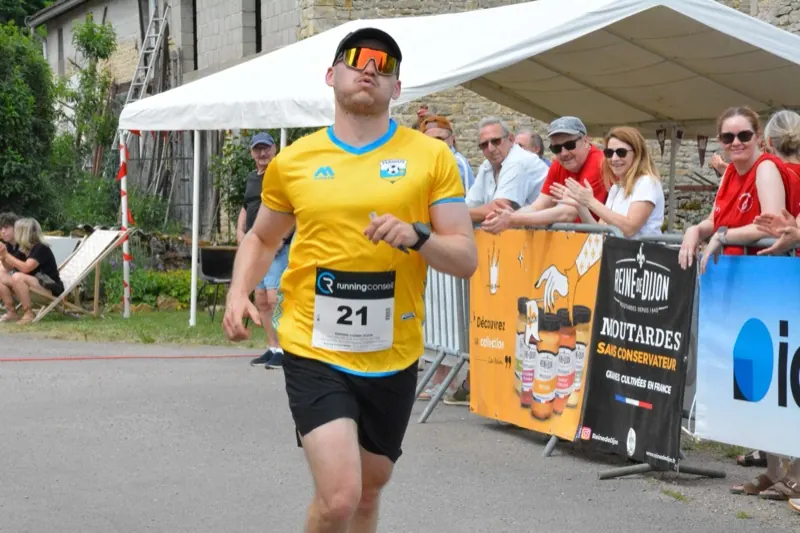 Un coureur en maillot jaune termine le trail de 15 km sous les applaudissements