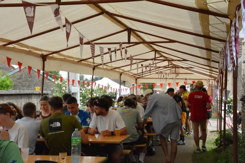 Coureurs et familles partagent le repas côtelettes sous le chapiteau